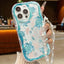 Phone case with turtle design held by a hand with a pearl bracelet.