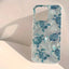 A clear phone case featuring a pattern of blue and teal sea turtles, shown on a light beige background with a soft shadow.