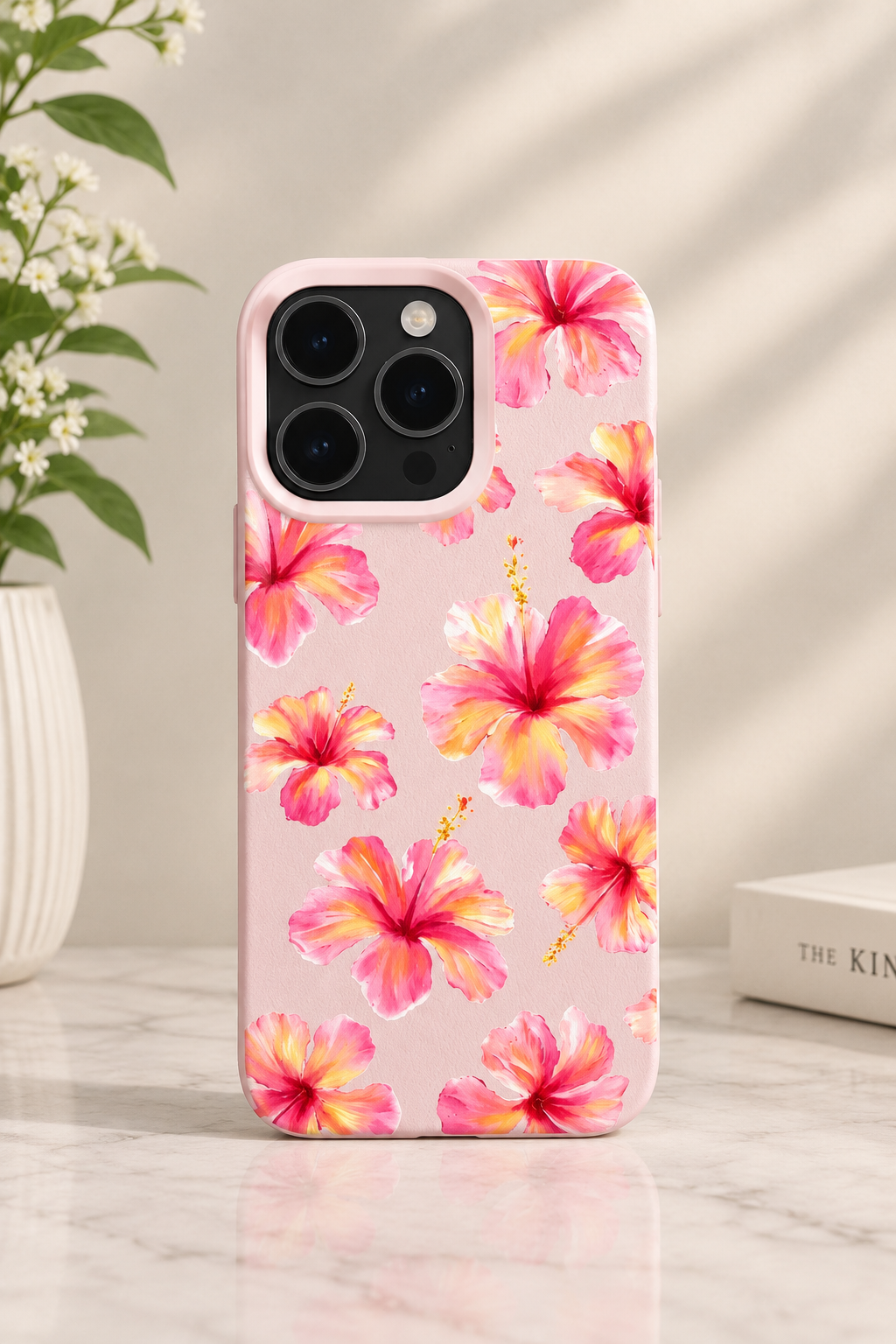 Soft pastel pink phone case featuring a light watercolor pattern of blooming pink and yellow hibiscus flowers.