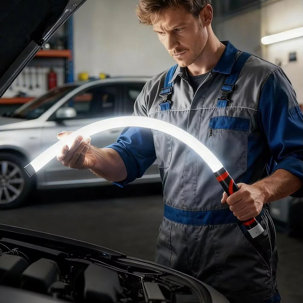 Mechanic inspecting a car with a flexible inspection light in a garage.