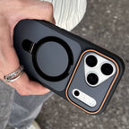 Hand holding a black phone case with a ring holder on a blurred background
