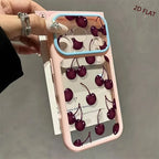 A hand holds a pink phone case decorated with a 3D cherry print, featuring a light blue camera bumper and a clear back panel showing the cherry pattern.