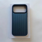 A dark teal phone case with a vertical ribbed design and a large camera cutout, displayed on top of its white packaging box against a light gray background.