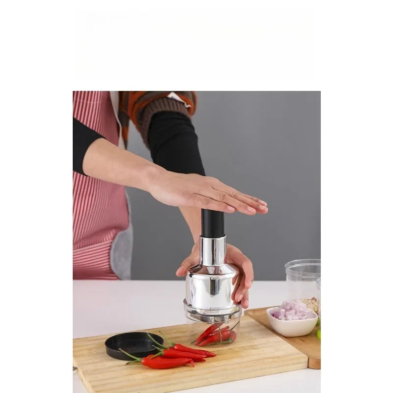 hands using manual chopper to quickly dice fresh garlic and vegetables on a chopping board