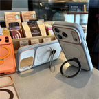Phone cases with ring stands on a surface, with Starbucks products in the background.