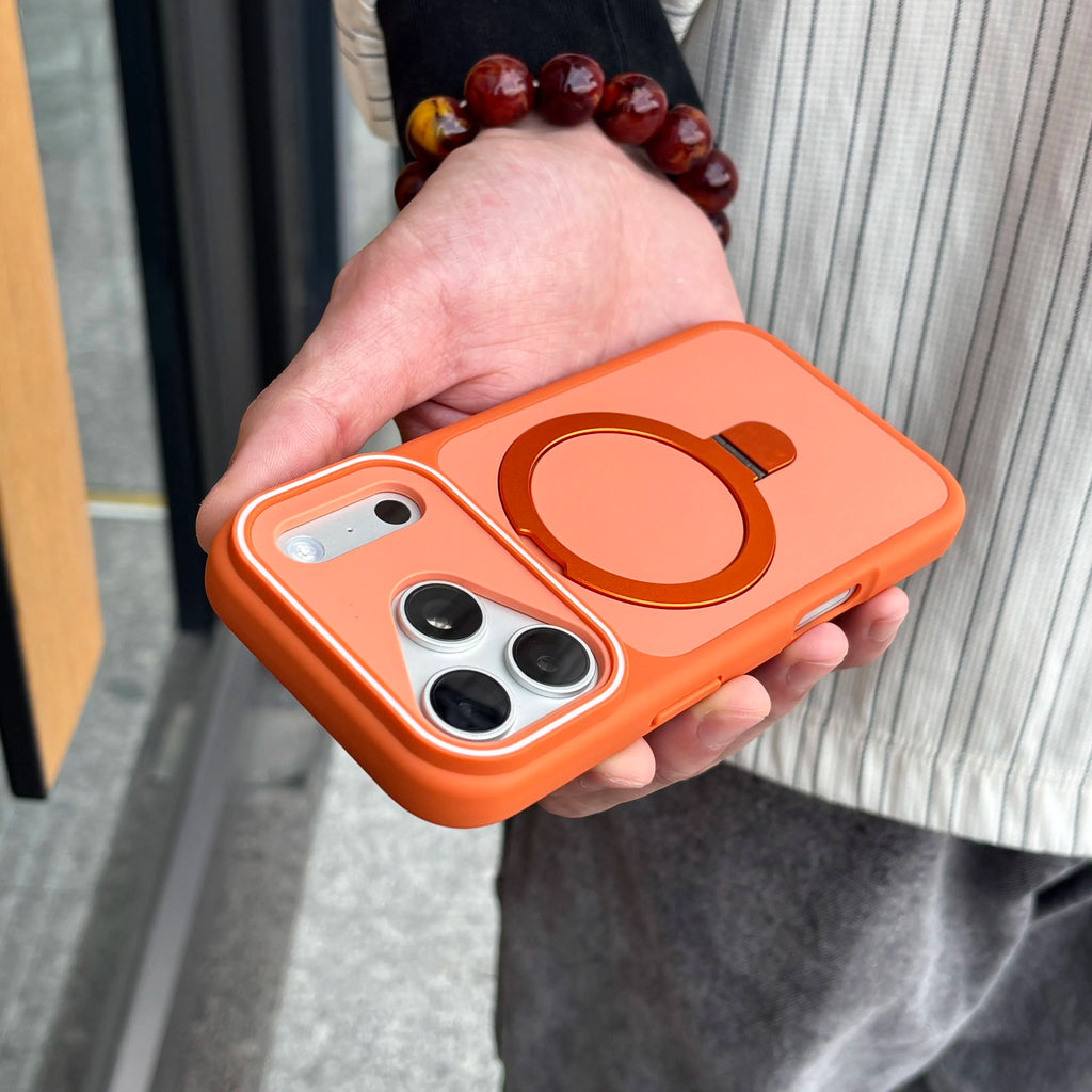 Orange phone case with a ring holder held by a person wearing a beaded bracelet.