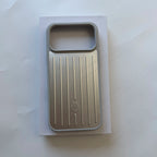 A metallic silver phone case with a vertical ribbed design and a small embossed logo, displayed on a white backing card against a light gray background.