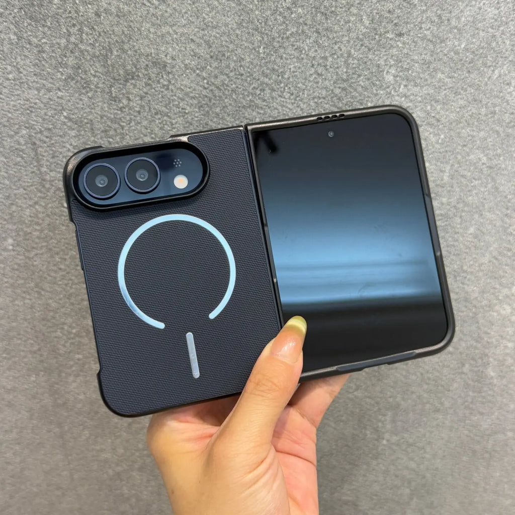 A black foldable smartphone case with a light blue magnetic ring design on the back, held open by a hand against a gray textured background.