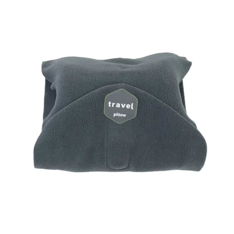 A dark gray fleece travel pillow with a hexagonal 'travel pillow' logo patch on the front, shown against a plain white background.