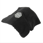 A black fleece travel pillow with a gray hexagonal patch that reads 'travel pillow', shown on a plain white background.