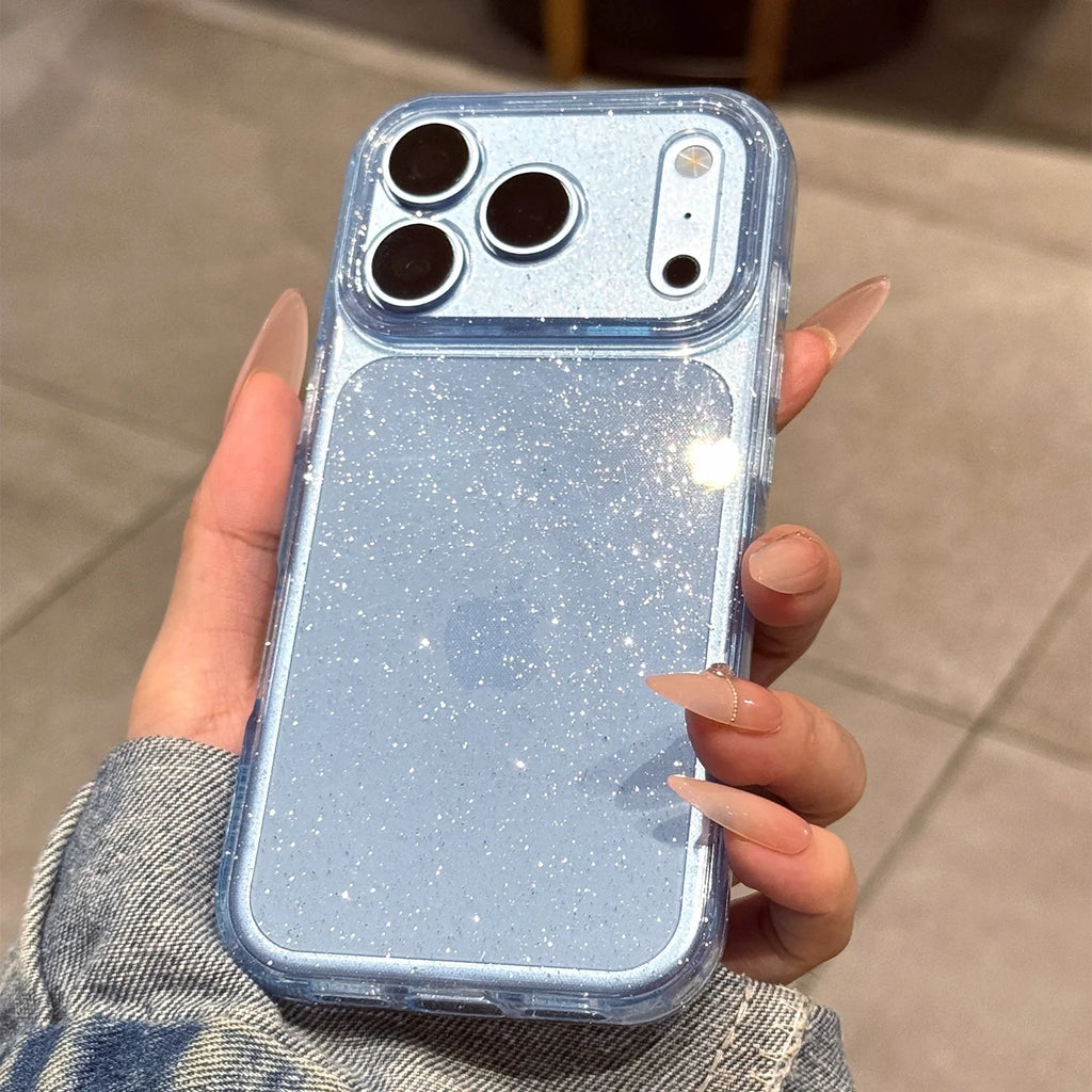 A hand with long manicured nails holds a light blue glittery phone case with a clear bumper, shown against a neutral tiled floor background.