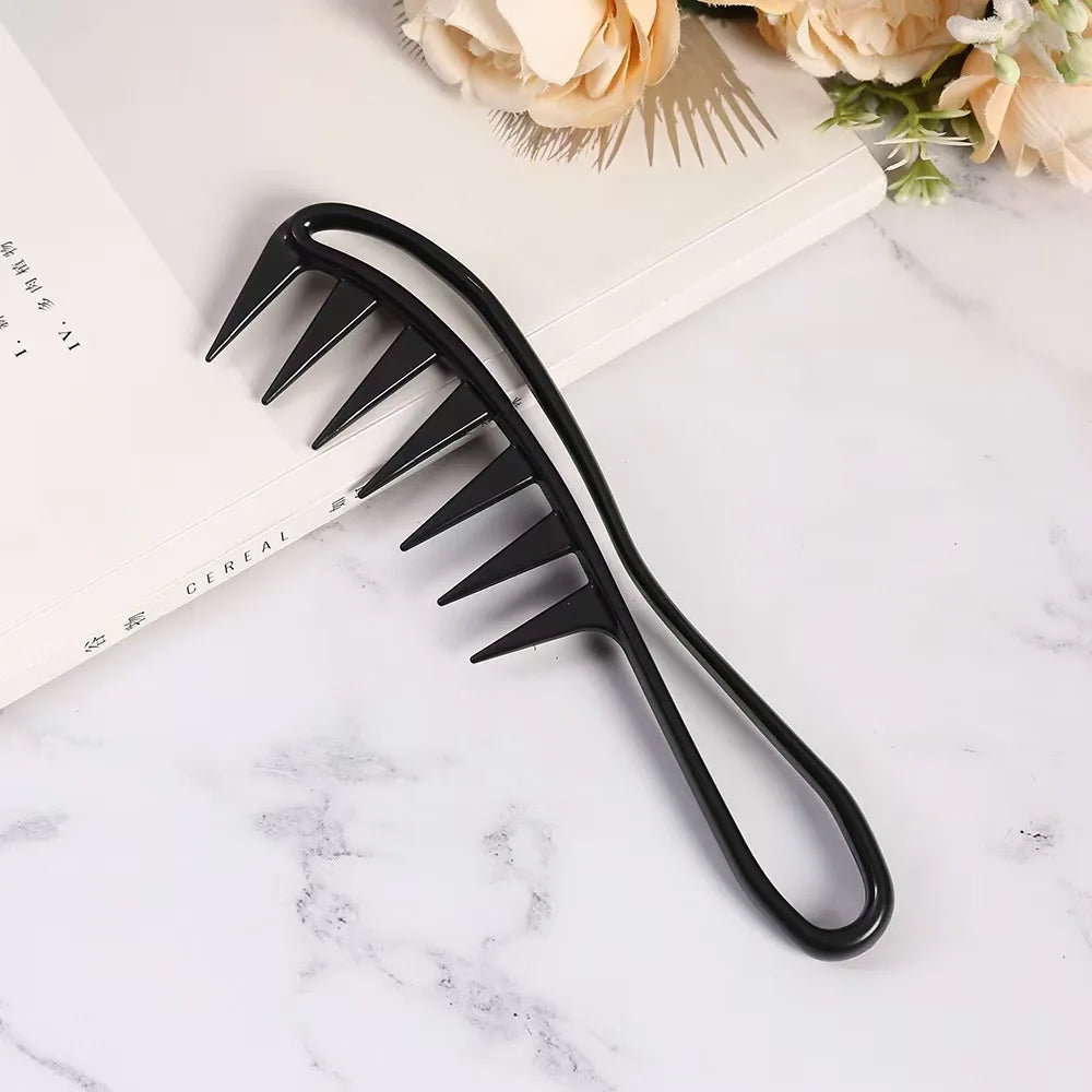 Black hair comb on a marble surface with flowers in the background