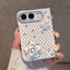 A hand holding a white phone case decorated with black polka dots, rhinestone flowers, and small clear rhinestones, shown against a neutral gray background.