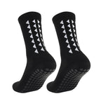 One pair of black football grip socks with white non slip rubber pads on the bottom for sports running and soccer