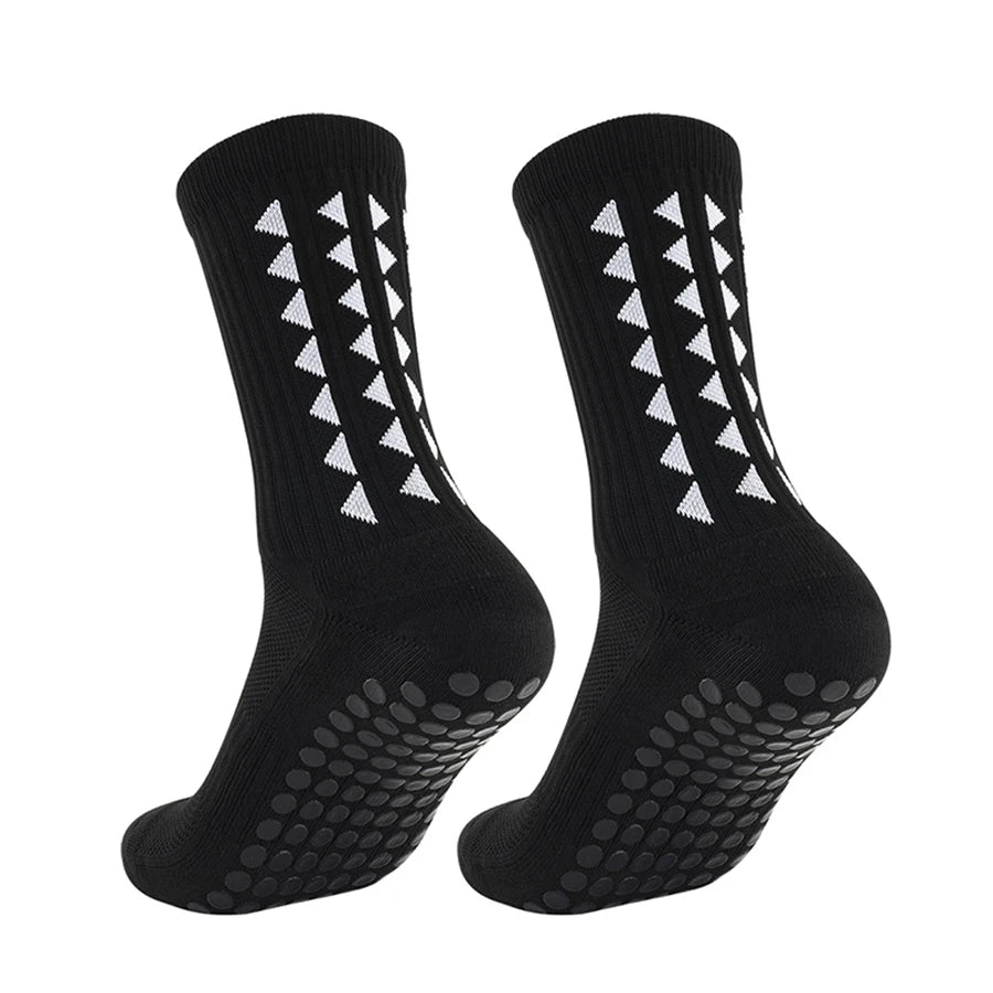 One pair of black football grip socks with white non slip rubber pads on the bottom for sports running and soccer