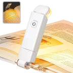 clip on reading light attached to open book emitting warm amber glow for eye protection late night reading