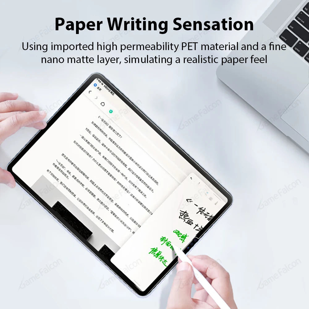 Tablet with writing on a screen, hands holding stylus, and laptop in the background.