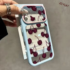 A hand holds a clear phone case with a light blue bumper and a pink inner bumper, decorated with a 3D cherry print. The case is shown with its white backing card, and the text '2D FLAT' is visible in the top right corner.