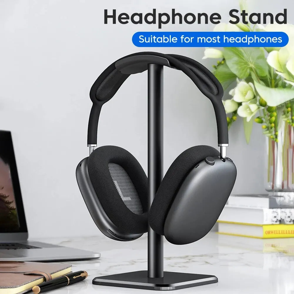 black aluminium headphone stand supporting over ear headphones on a tidy home office workstation