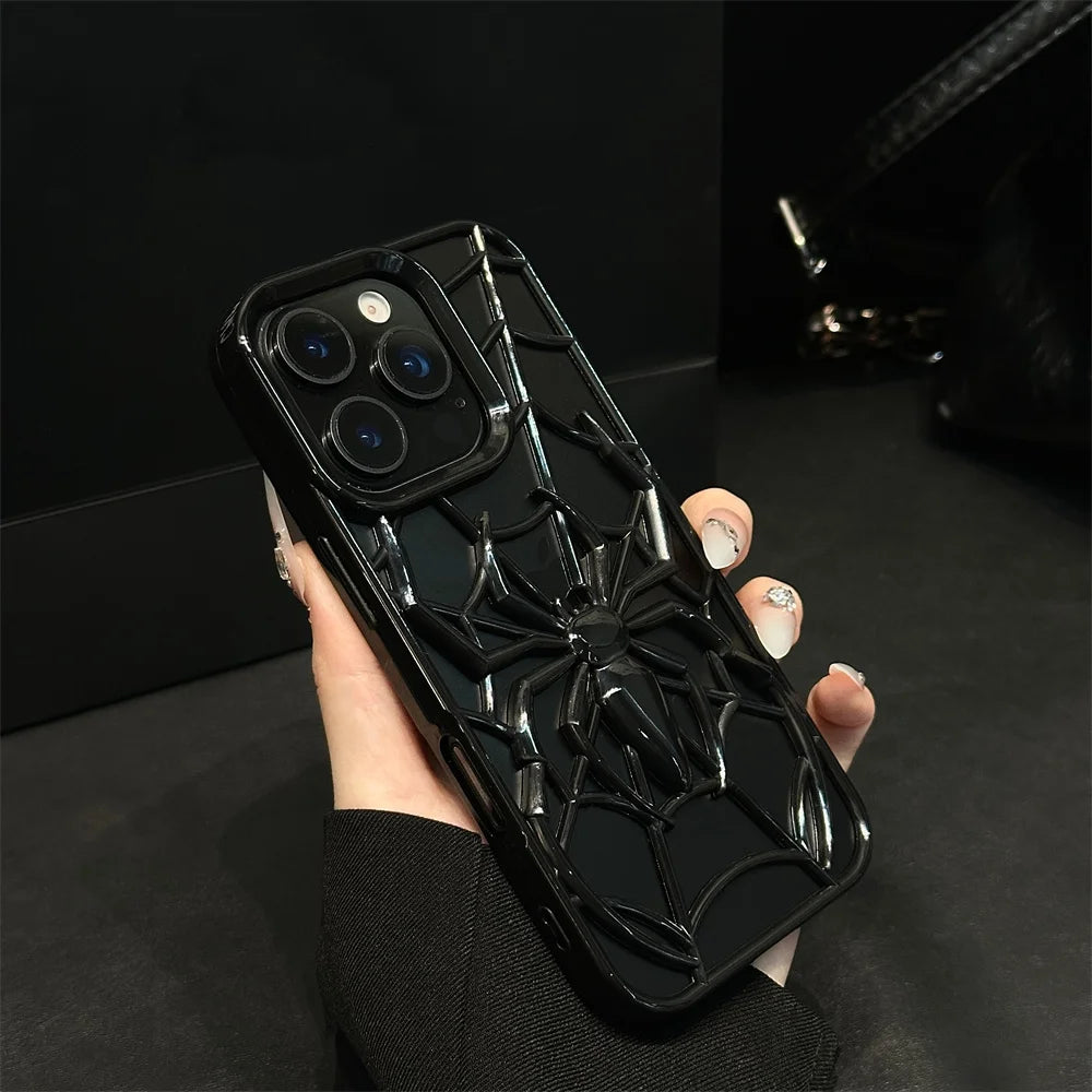 Person holding a phone with a black spider web design case against a dark background
