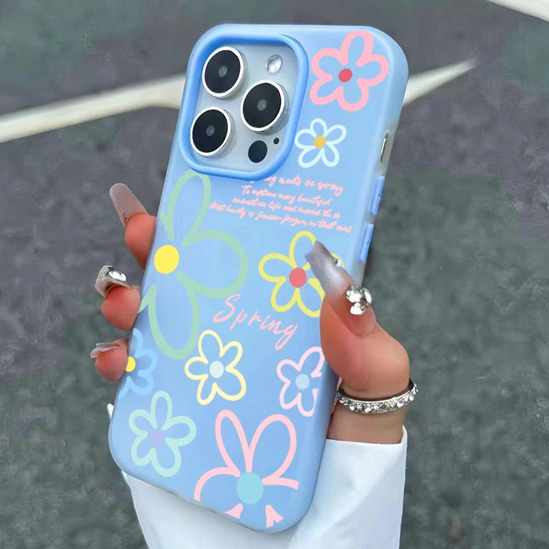 Blue phone case with floral designs held by a hand against a dark background