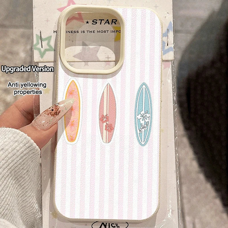 A hand holds a white phone case with vertical stripes and three colorful surfboard designs. The case has a clear camera window and text on the back reads 'STAR' and 'NESS IS THE MOST IMP.