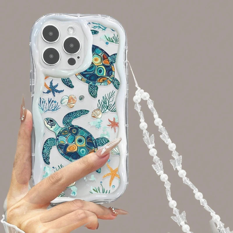 Phone case with turtle design held by a hand against a neutral background