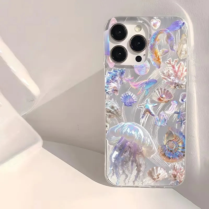 A clear phone case with an iridescent, holographic jellyfish and sea urchin design, shown on a white smartphone. The case features a mix of pastel purple, blue, pink, and green shimmering elements on a transparent base.