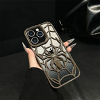 Phone case with spider design held by a hand against a dark background