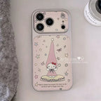 A light pink textured phone case with a Hello Kitty design, featuring a large camera cutout and a decorative illustration of Hello Kitty in a pink hat with stars and hearts, shown on a light surface with a gray knit fabric and a cosmetic jar nearby.