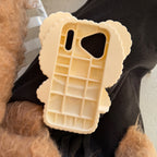 Phone case shaped like a waffle held by a person with a dog.