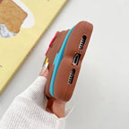 Phone case with brown back and blue edge held by a person wearing a white sweater.