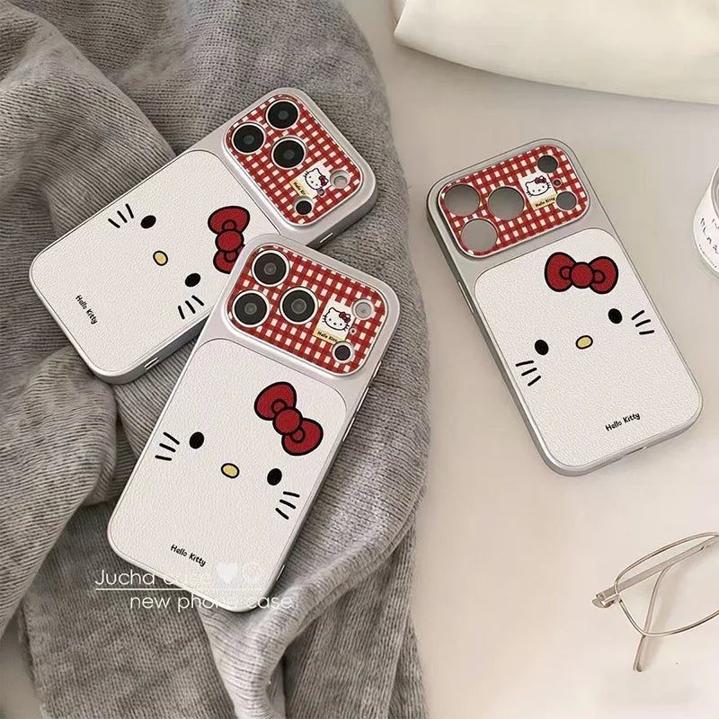 Three Hello Kitty phone cases arranged on a light surface with a gray textured fabric. The cases are white with red and white gingham camera sections, red bows, black facial features, and small yellow accents.