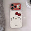 A Hello Kitty phone case shown from above on a light surface, with a red-and-white gingham camera section and a large white face area with a red bow, black whiskers, and the Hello Kitty name printed near the bottom.