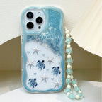 Light blue ocean turtle iPhone case highlighted with wavy edge protection and a clear bead string lanyard.