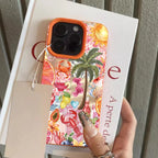 Phone case with tropical design held by a hand, with a book in the background