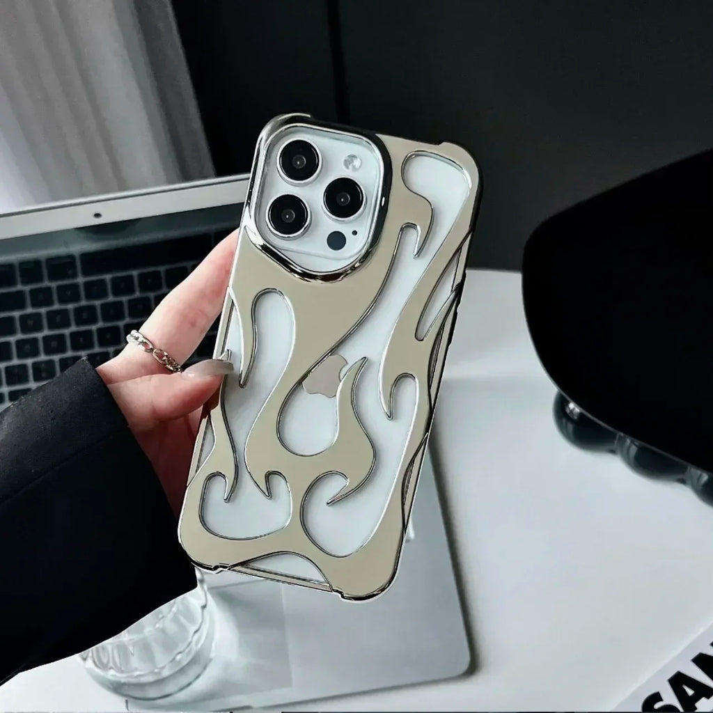 Phone case with flame design held by a hand in front of a laptop.