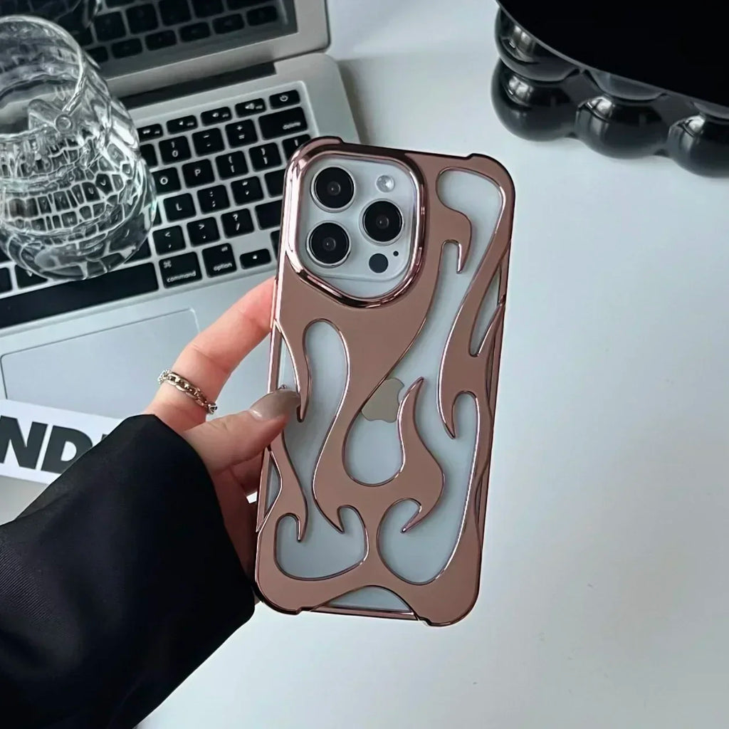 Phone case with flame design held by a hand, laptop and glass in the background