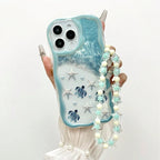 Light mint blue turtle iPhone cover showing wavy edge frame and decorative bead string accessory