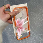 Phone case with pink flower design held by a hand against a gray background