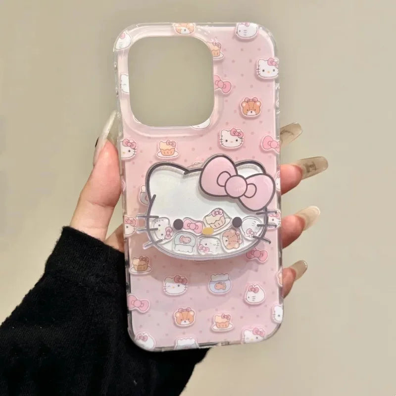 A hand holding a clear phone case decorated with a pink Hello Kitty pattern and a large 3D Hello Kitty face on the back, set against a plain beige background.