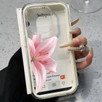Phone case with pink flower design held by a hand on a gray surface