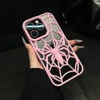 Phone case with pink spider design held by a person against a dark background