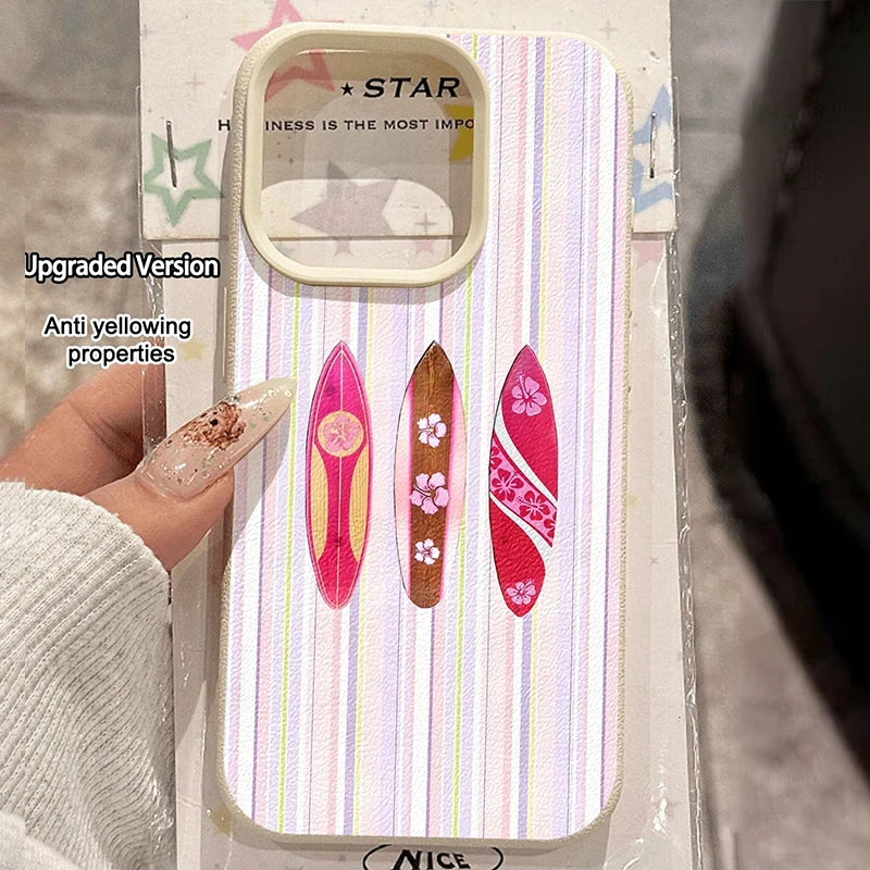 A hand holds a packaged phone case with a pastel vertical stripe pattern and three colorful surfboard designs. The package includes printed text such as 'STAR' and 'INNESS IS THE MOST IMP.