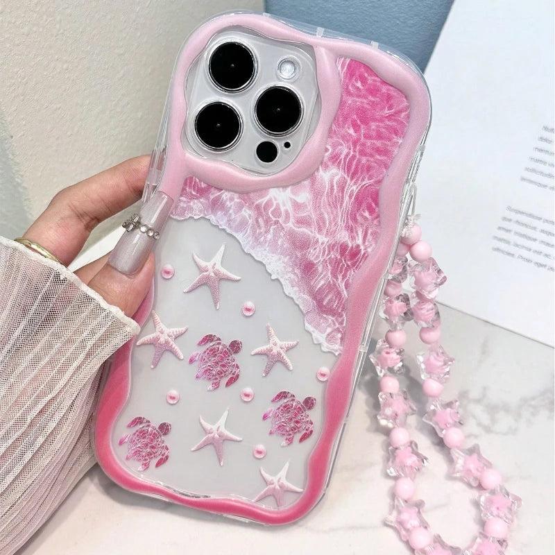 Cute pink summer turtle iPhone case with wavy protective edges and attached clear beaded wrist strap.