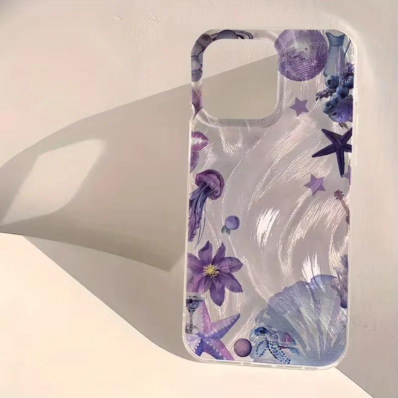 A clear phone case with a purple and blue underwater theme print, featuring jellyfish, starfish, seashells, and sea plants, displayed on a warm off-white surface with a soft shadow.