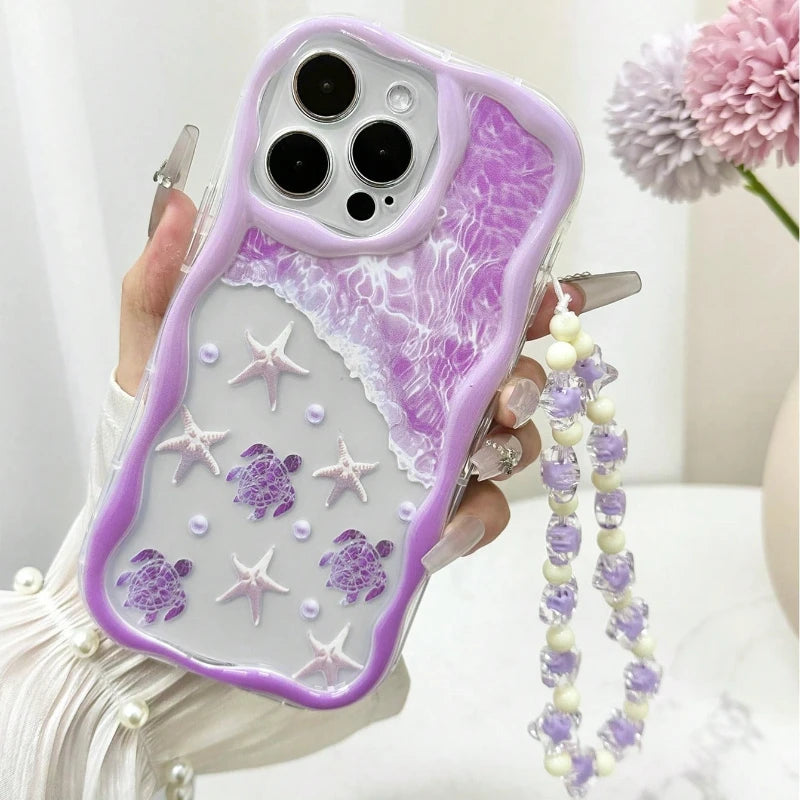 Stylish purple turtle graphic iPhone case designed with wavy edge borders and a clear bead string charm.