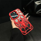 Phone case with spider design held by a hand against a dark background