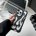 Person holding a phone with a black and white flame-patterned case in front of a laptop.