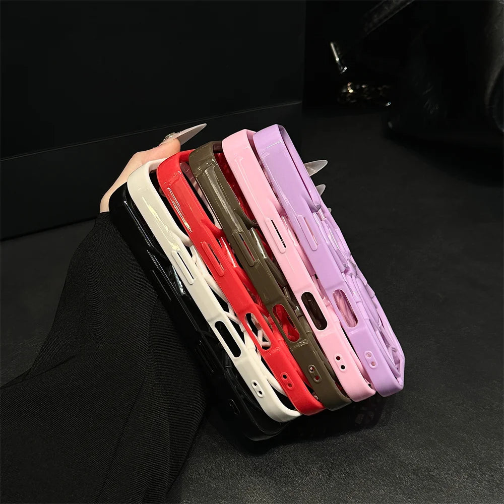 Five phone cases in different colors arranged on a dark surface.